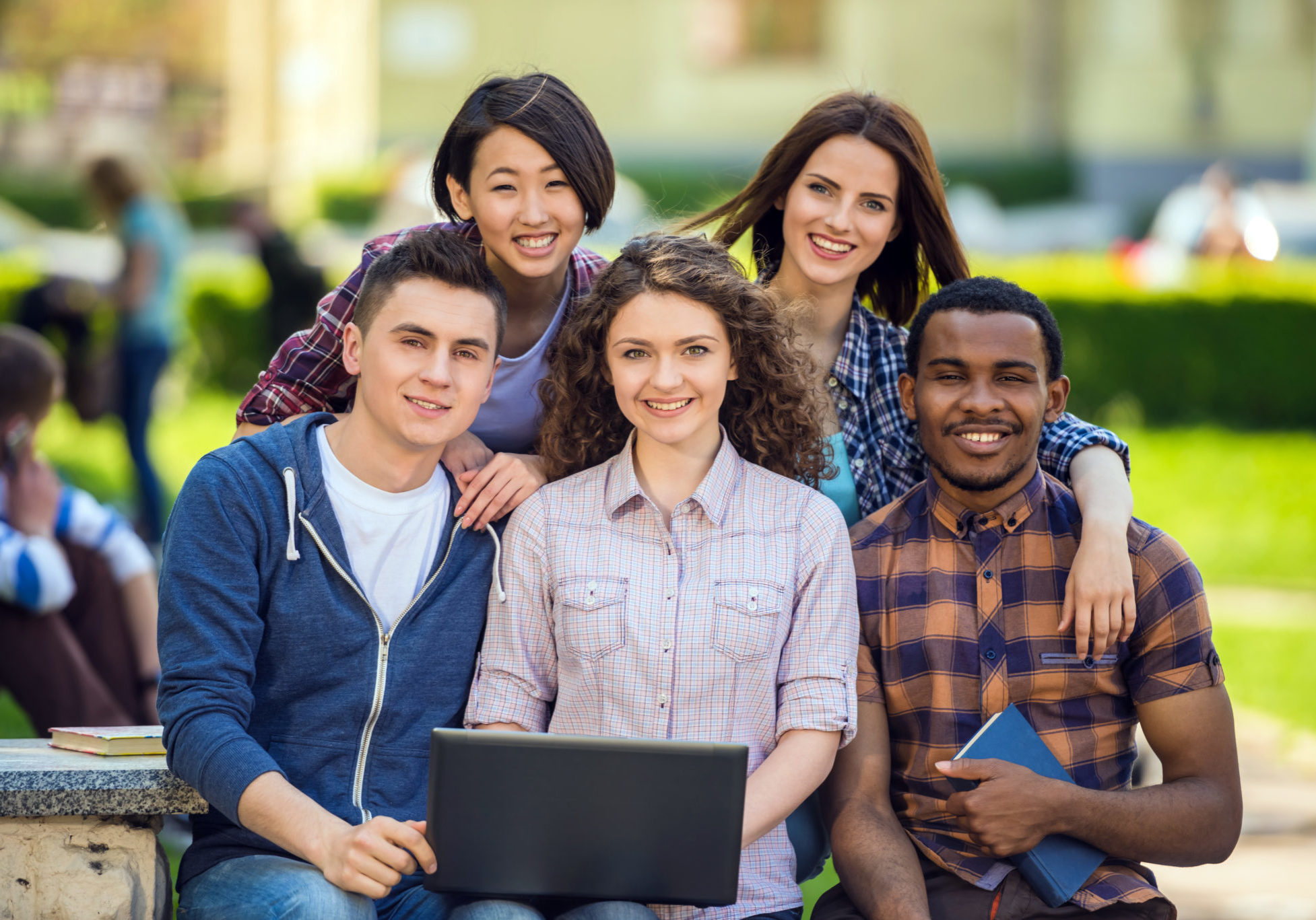 Group of young attractive smiling students dressed casual sitting on the staircase outdoors on campus at the university.